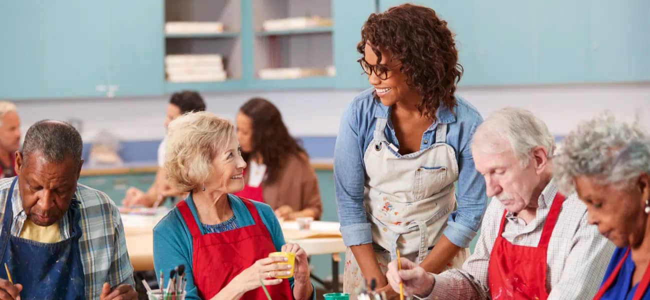 An activity director leading an art class with seniors at a Tucson care community