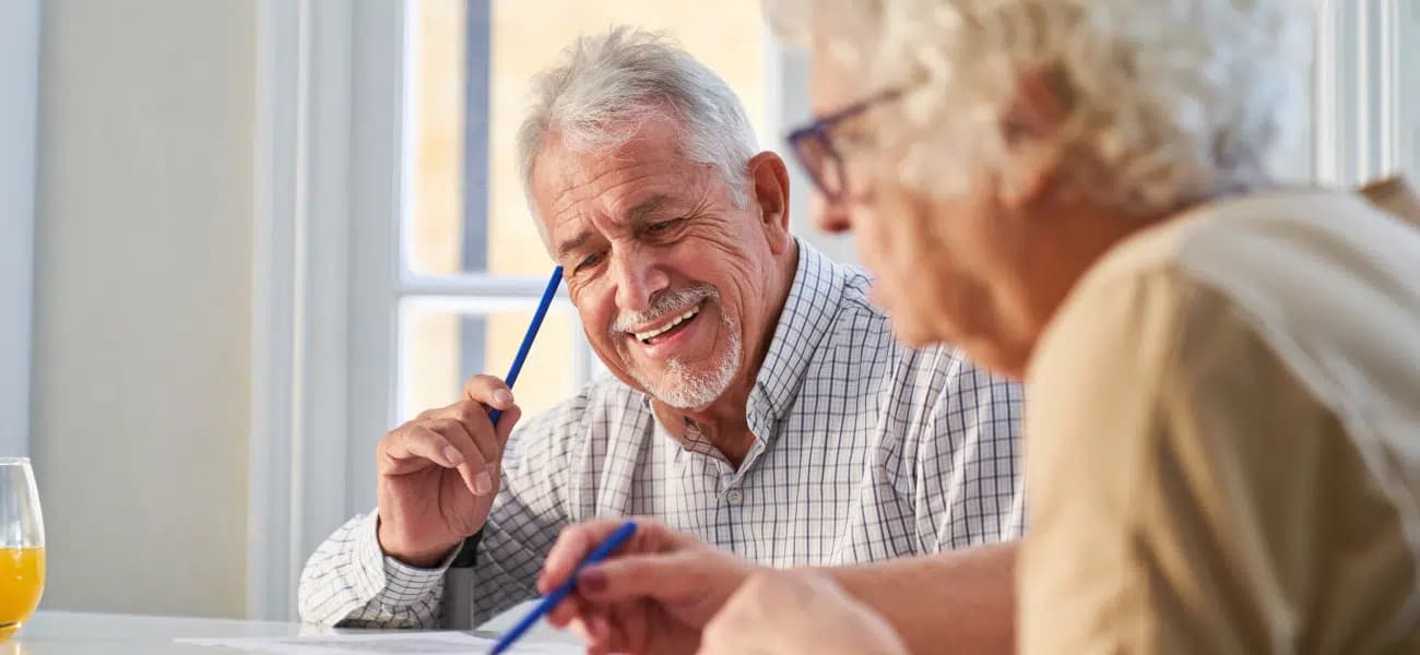 An older couple reviewing care paperwork together at a table